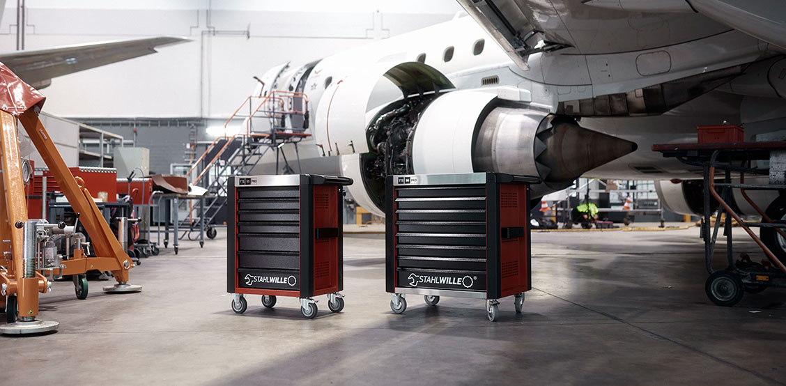 Two tool trolleys standing in front of an aircraft in the hangar