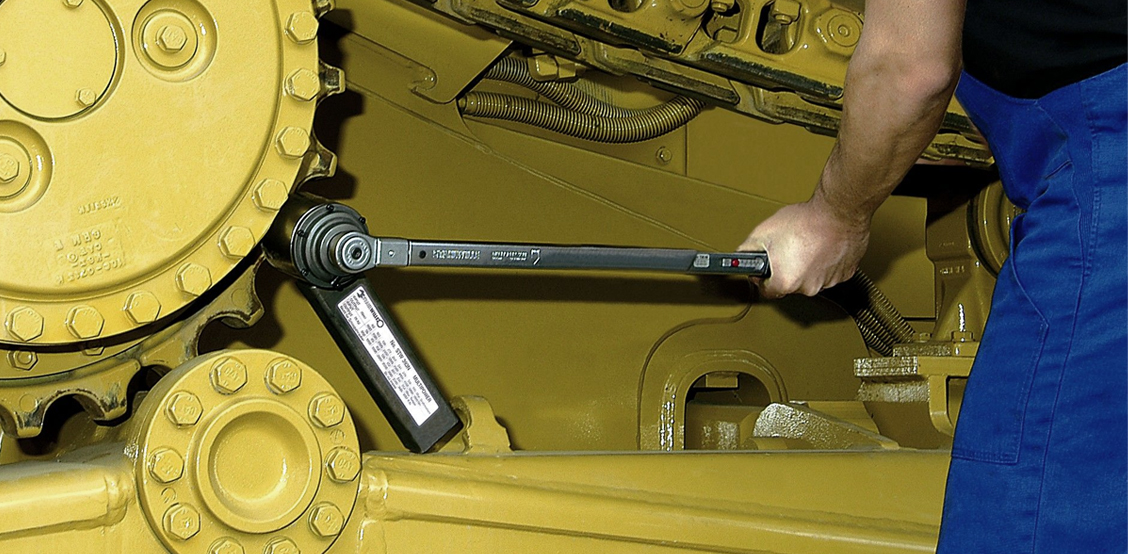 Un multiplicateur de couple STAHLWILLE associé à une clé dynamométrique utilisés pour serrer avec précision un assemblage de grande taille sur un véhicule de chantier.